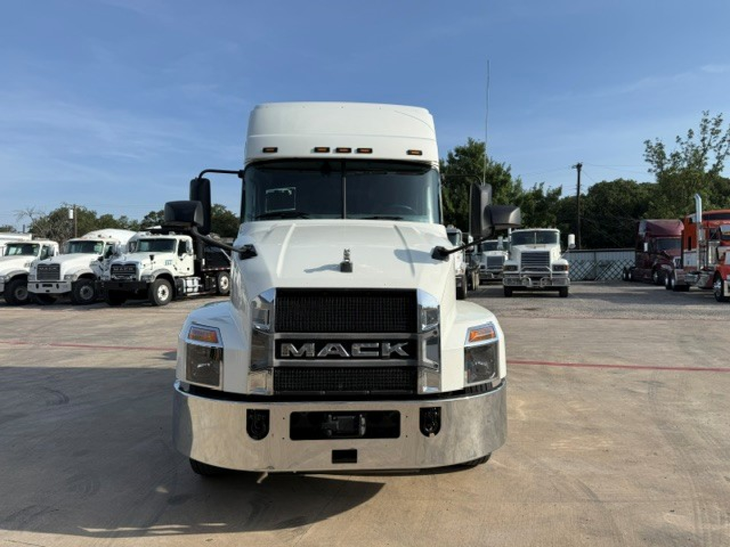 Truck front view of a white 2020 Mack ANTHEM sleeper cab showing Mack grille and bumper.