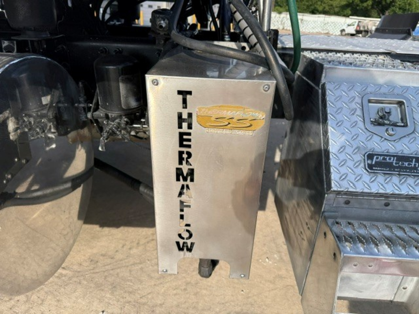 Thermal system panel with 'THERMAL' vertical text and a chrome cabinet on a Mack truck chassis showing diamond plate storage box and fuel/air tanks