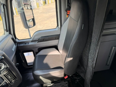 Truck cab interior showing driver seat and part of dashboard in a Mack Anthem sleeper cab.