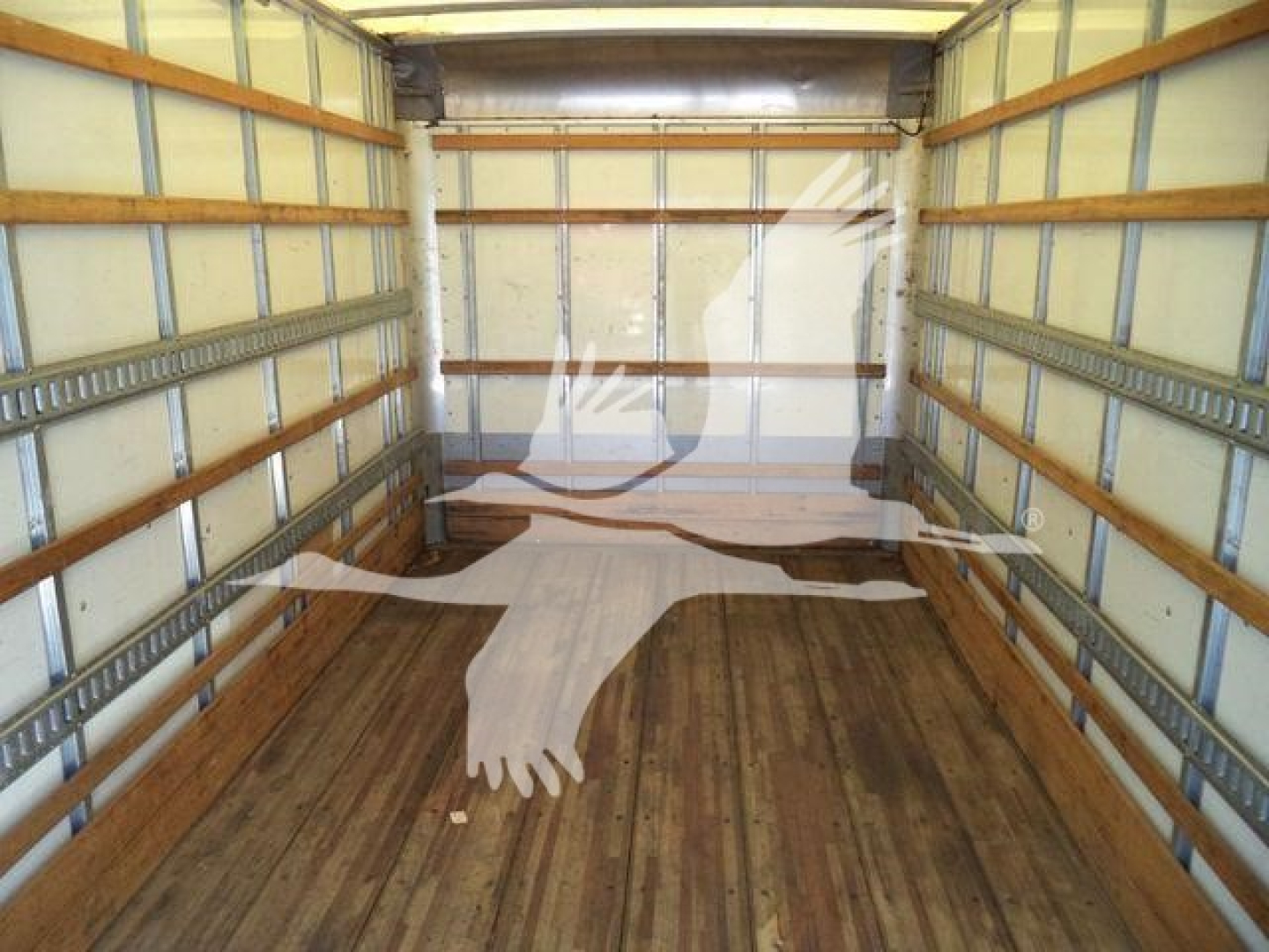 Isuzu NPR-HD box truck interior showing empty cargo area with wooden floor and metal side rails.