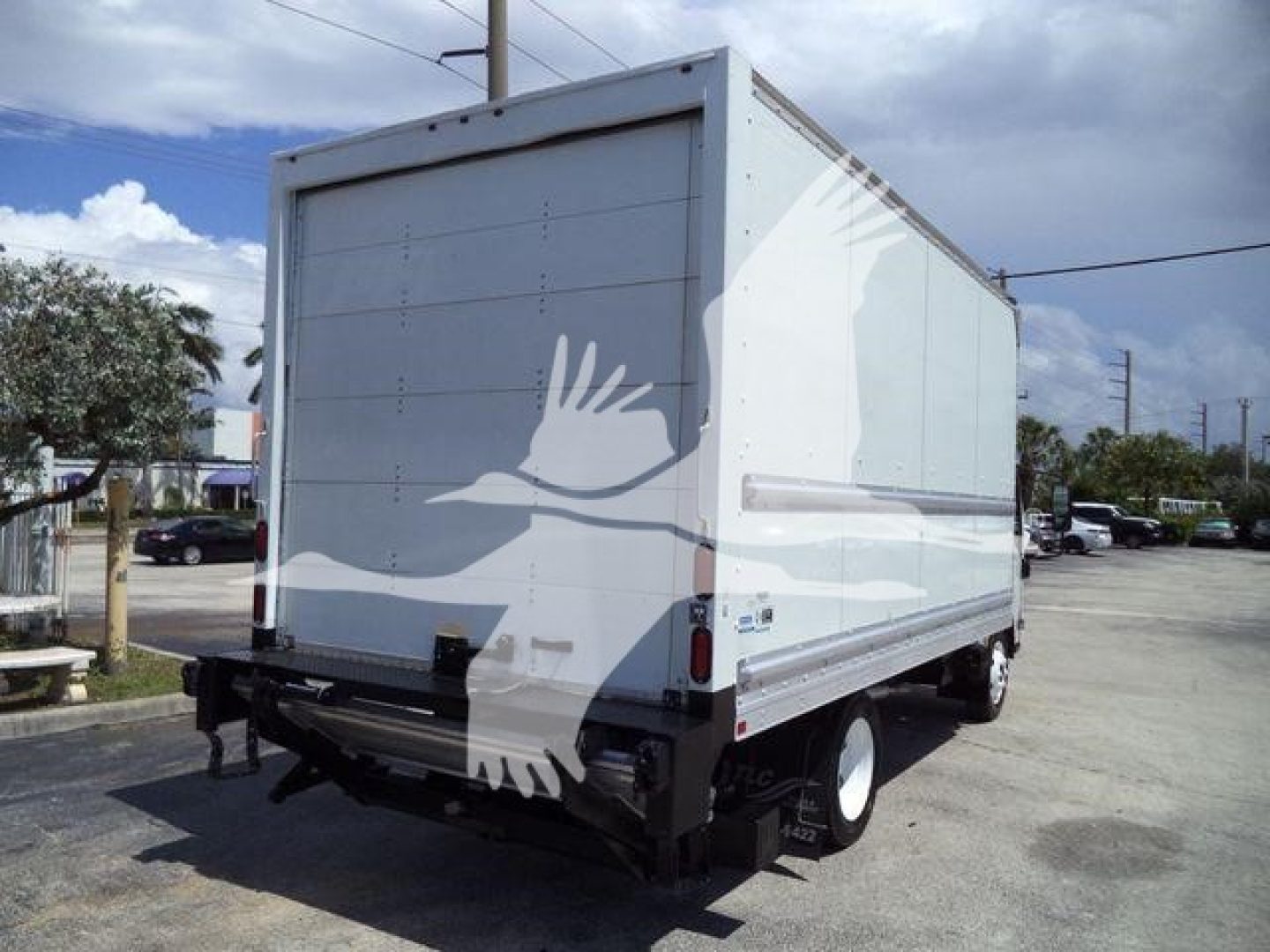 Isuzu NPR HD box truck from rear-right side showing cargo box with white exterior and rear bumper.
