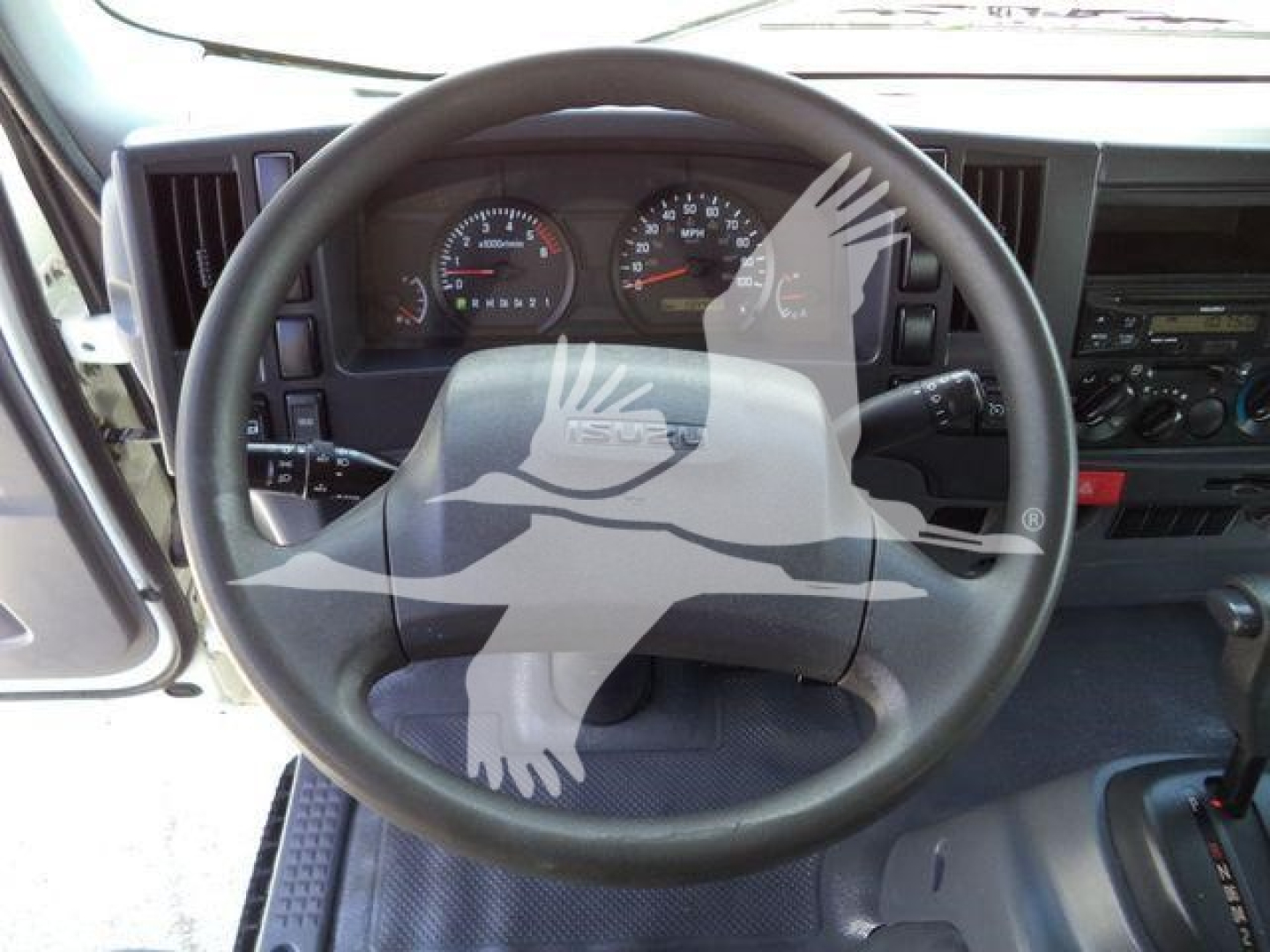 Isuzu NPR HD truck interior showing steering wheel, dashboard gauges, and VP-style instrument cluster.