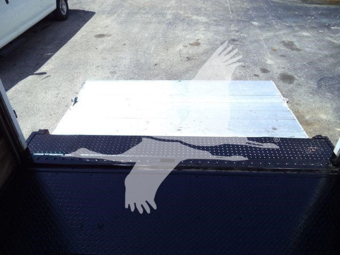Truck bed area of 2016 Isuzu NPR HD with ramp/step and metal surface visible.