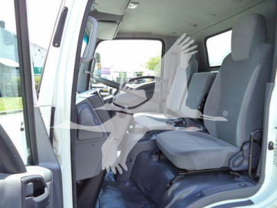 Isuzu NPR-HD cab interior showing front seats and dashboard from open driver door perspective.