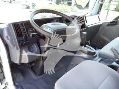 Isuzu NPR HD cab interior showing steering wheel, dashboard, and gear shift.