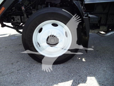 Isuzu NPR HD truck wheel and tire visible with white steel wheel and black tire; part of truck undercarriage seen.