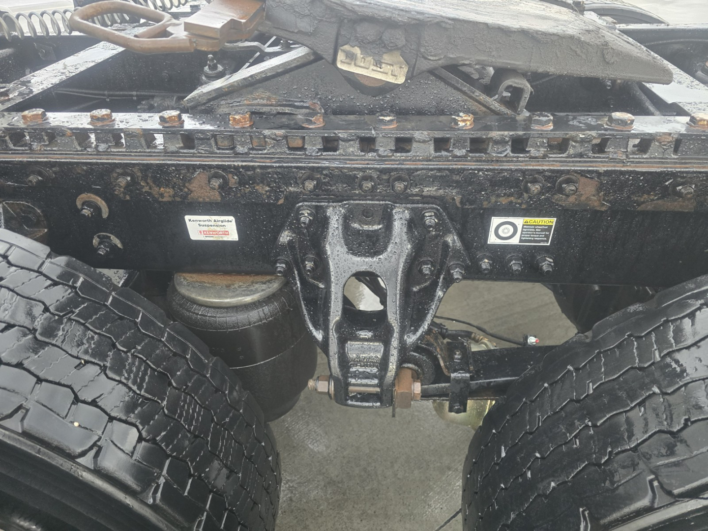 Kenworth T680 chassis with dual rear axles showing frame and air suspension components.