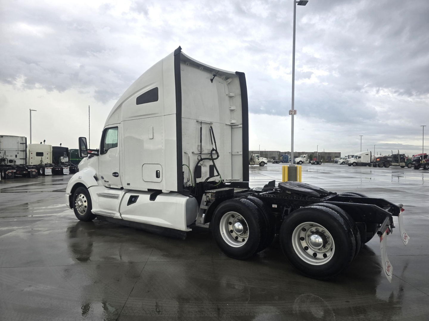 Kenworth T680 tractor cab in-service side view showing sleeper area and rear axles with fifth-wheel area.