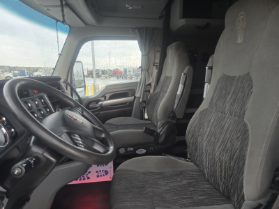 Kenworth T680 truck cabin interior showing driver seat and passenger seat with steering wheel and dashboard visible.