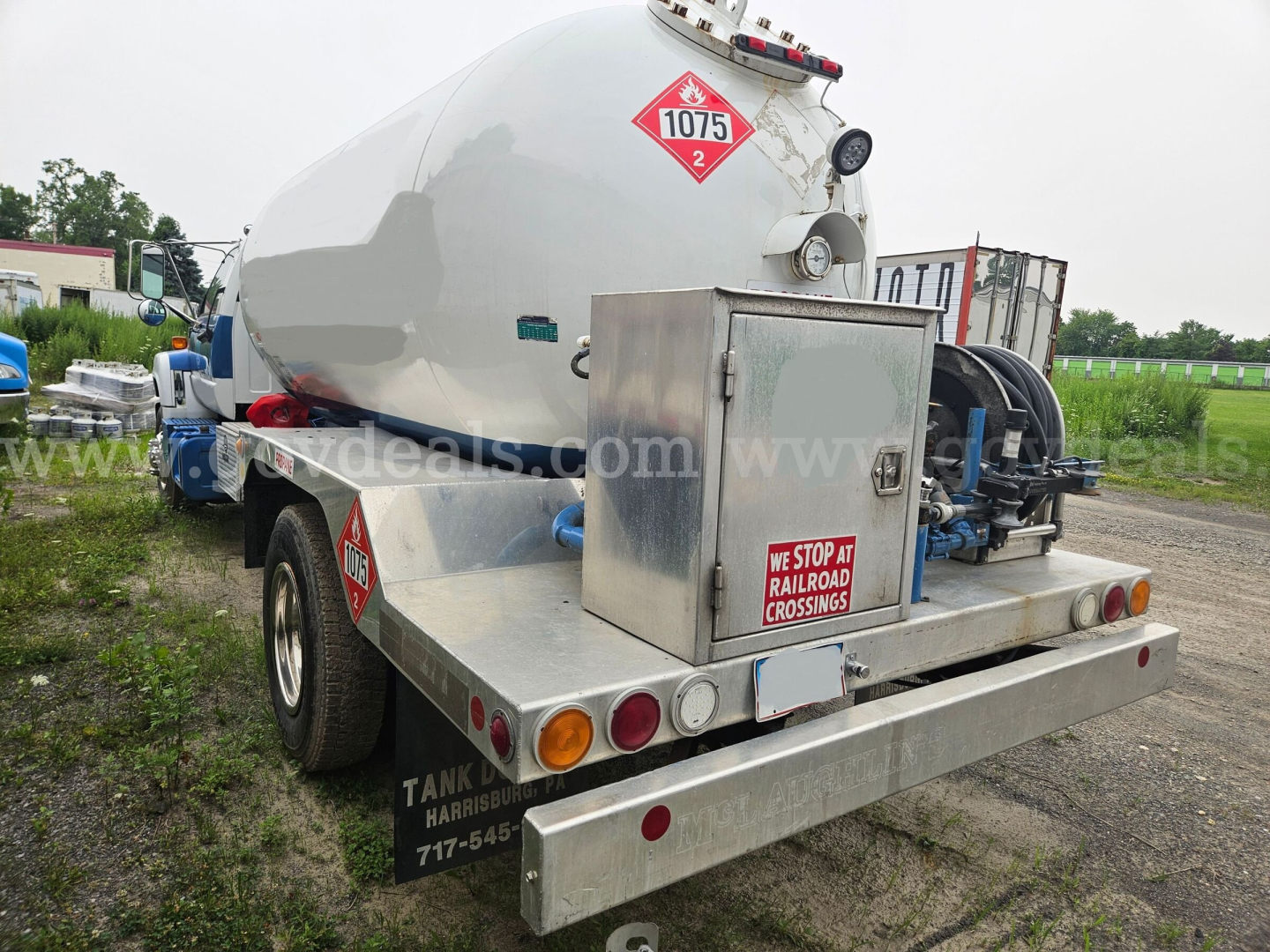Tank trailer rear showing cylindrical tank, hazard placard 1075, rear toolbox, and bumper with lights.