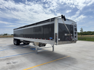 Trailer showing Stoughton 40' alum grain hopper with 68" sides, front gooseneck, undercarriage with landing legs, two axles, silver/gray panels, and reflective tape.
