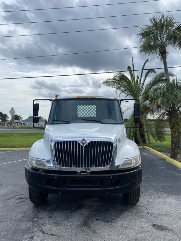Front view of a white 2018 International 4300 truck with large grille, bumper, and side mirrors in a parking lot.