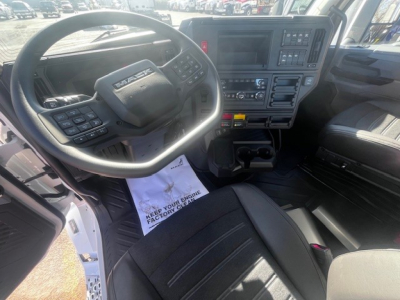 Mack PR64T truck interior showing steering wheel, dashboard, and center console with controls and display.