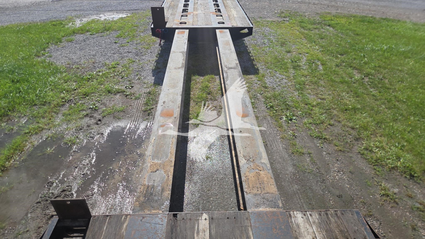 Trailer bed of a 1991 Trail King TK90ED482 lowboy showing steel I-beam frame and tandem tracks