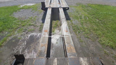 Trailer bed of a 1991 Trail King TK90ED482 lowboy showing steel I-beam frame and tandem tracks