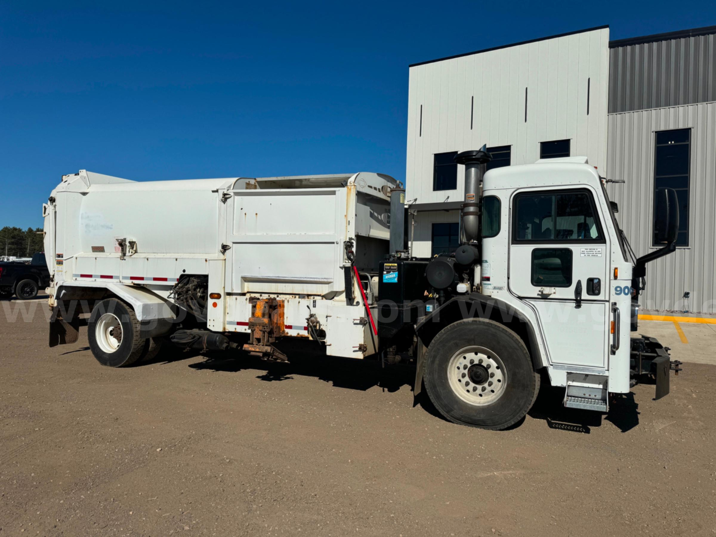 Peterbilt 2018 PB520 dump truck side view showing chassis and dump body with white cab and white bed.