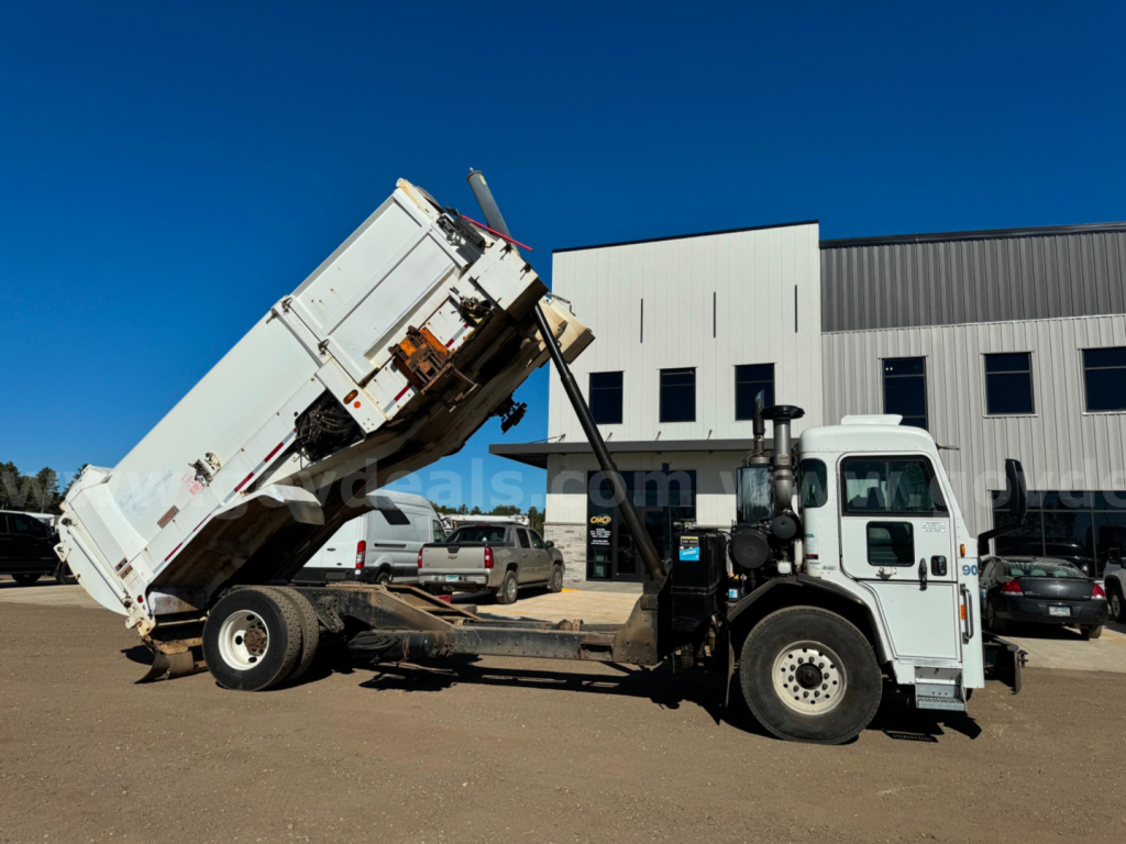Peterbilt PB520 truck with dump bed raised in a yard showing side view and loading area.