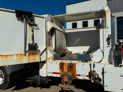 Peterbilt PB520 dump truck rear/side view showing open bed and rusted mounting, side panels, hydraulic components, and chassis wear.