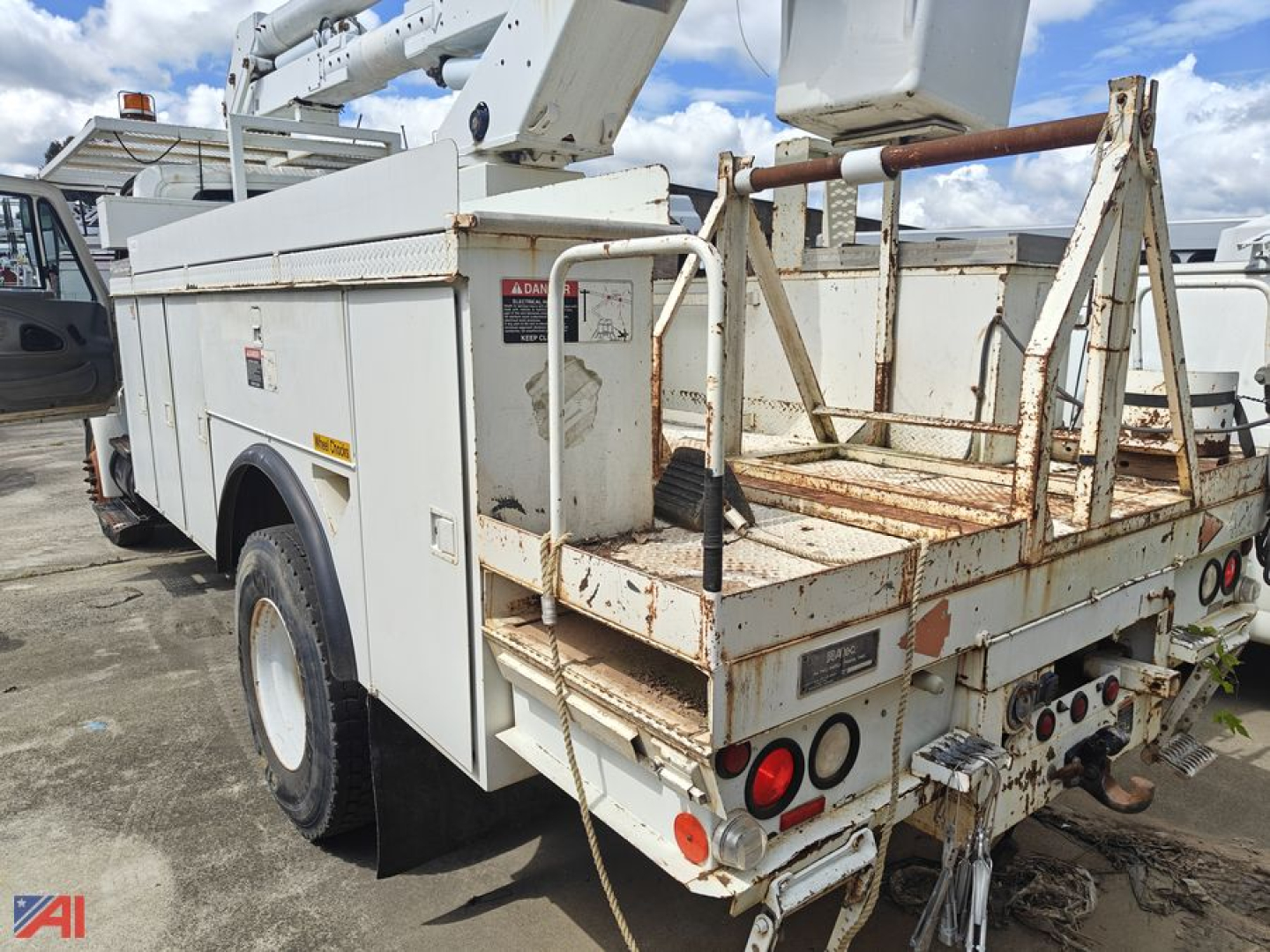 Bucket truck platform and utility body on a 2003 International 4300 with hydraulic boom, back view showing rear cage and taillights
