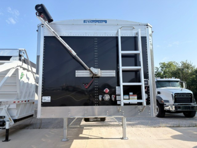 Stoughton 42' alum grain hopper trailer rear view showing 74-inch flat sidewalls, black exterior, rear ladder on right, swing-up tarp bar, and nose toolbox; VIN visible on plate, stock number 73732.