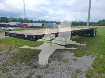Flatbed trailer in a grassy lot showing dual rear axles and wooden deck with black frame, 2024 Fruehauf steel flatbed, VIN 3AWF1PT25RX391007, stock 53-6180.