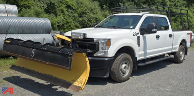 Ford F-350 Super Duty XL crew cab pickup with front plow attachment, white, side view, daytime outdoor lot.