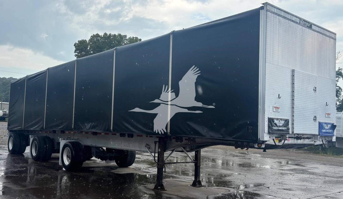 Trailer side view showing curtainside aluminum flatbed trailer with black outer sides and white crane graphic, front end with diamond plate toolbox and landing gear.