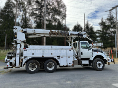 International 7400 digger-derrick truck side view showing boom and utility compartments