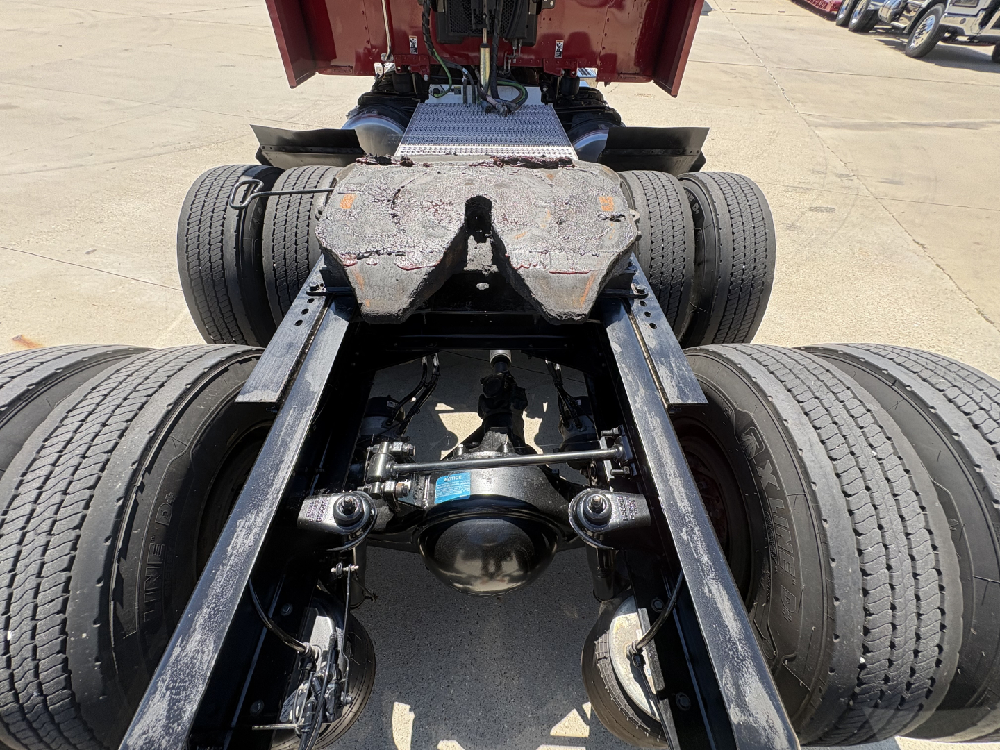 Peterbilt 579 chassis view showing rear dual axles, drive shaft, suspension, and fifth wheel mounting area.