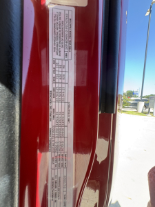 Peterbilt 579 door jamb label showing specifications and weights (VIN 1XPBD49X2PD747640) on red truck body.