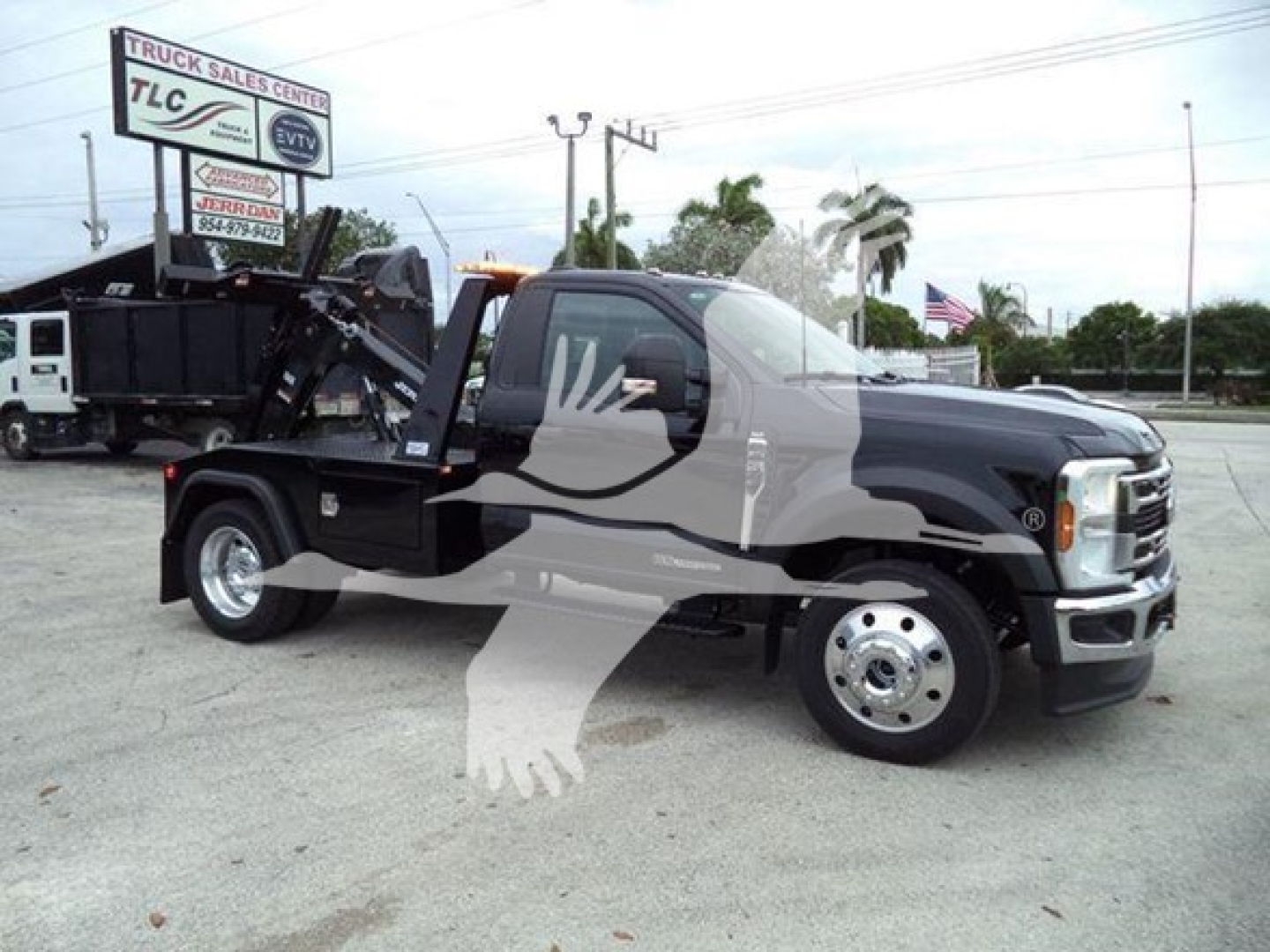 Ford F-450 tow truck in black showing wheel and winch bed with TLC sign in background