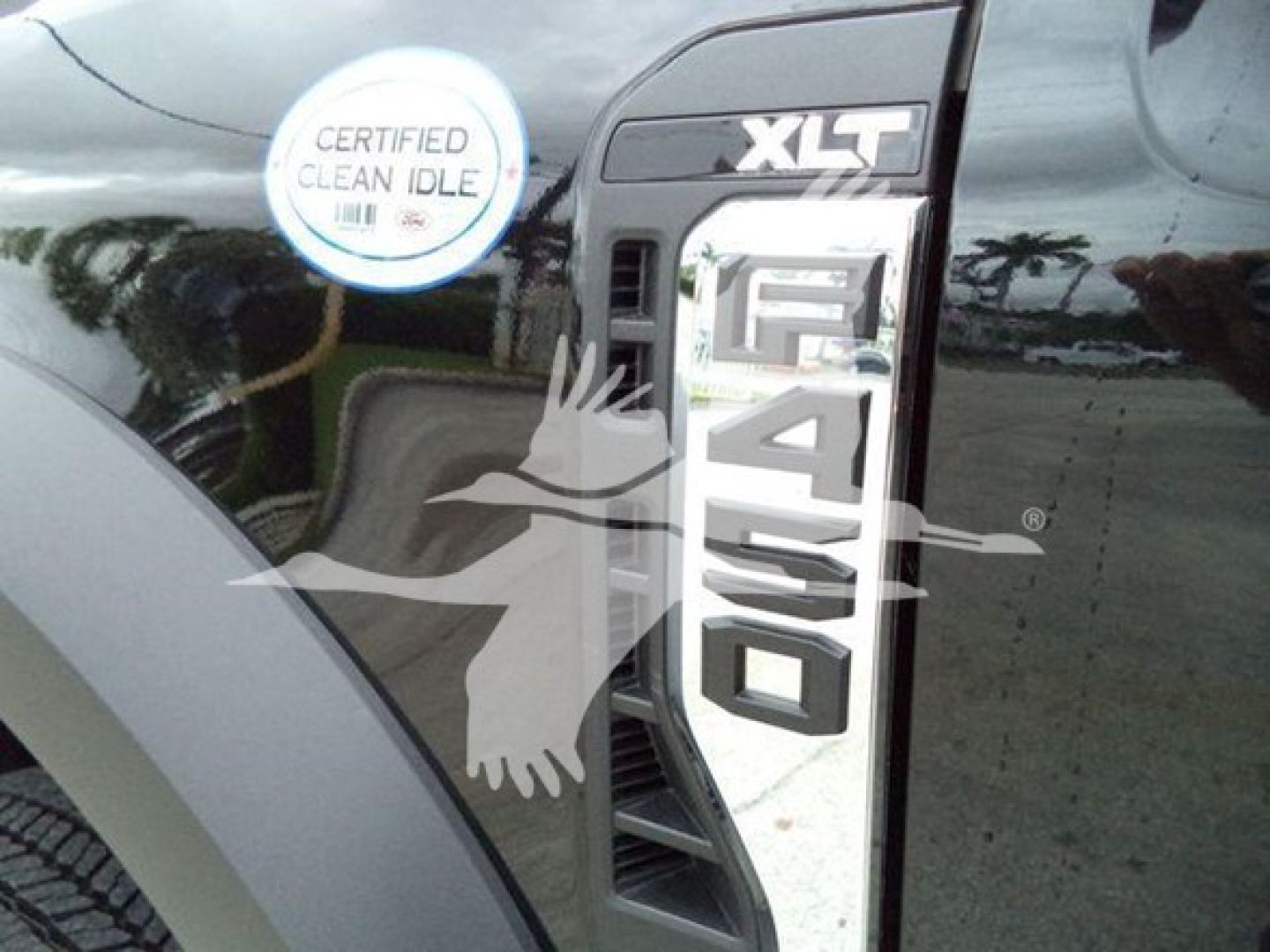 Ford F-450 XLT badge on side with large 450 sticker and a circular sticker reading 'CERTIFIED CLEAN IDLE' on a black truck door