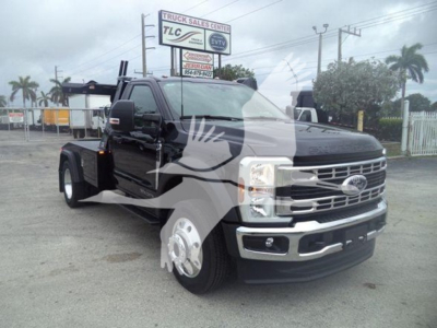 Ford F-450 pickup truck in black, front three-quarter view with winch equipment in a dealership lot.