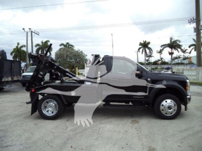 Ford F-450 tow truck with winch setup in side profile view showing front and rear dual rims and winch apparatus attached to bed.