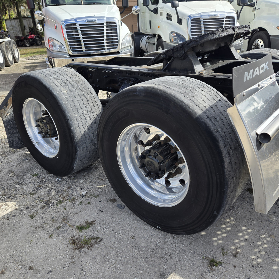 Mack ANTHEM day cab truck chassis showing dual rear axles and large aluminum wheels with tires.