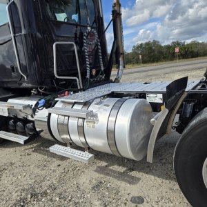 Trailer-tractor fuel tank and side view of Mack ANTHEN day cab truck showing cylindrical aluminum fuel tank, steps, and chassis with hoses.