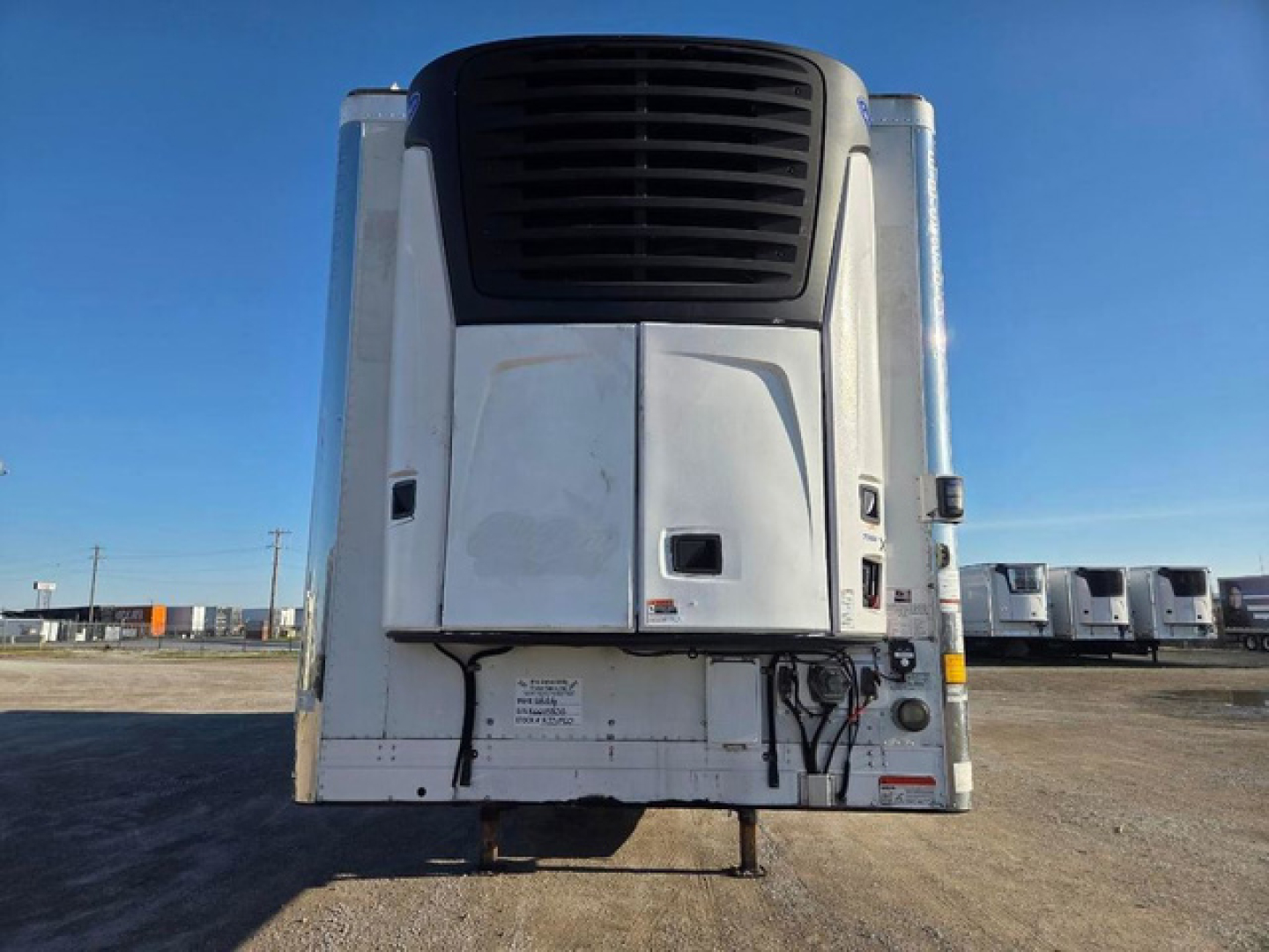 Utility reefer trailer rear view showing vertical refrigeration unit with black grille and white exterior panels.