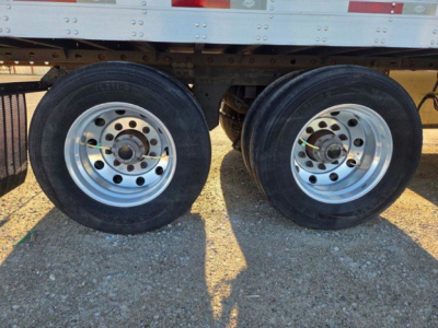 Dual rear trailer tires with silver rims on a refrigerated trailer, no legible text visible on tires.
