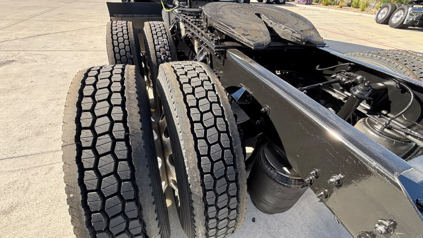 Kenworth T680 chassis rear view showing dual rear axles and dual tires, fuel tank, and frame rails.