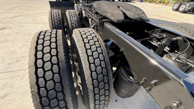 Kenworth T680 chassis rear view showing dual rear axles and dual tires, fuel tank, and frame rails.