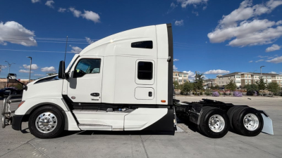 Kenworth T680 truck side view showing cab and chassis with wheels; white exterior with black trim and sleeper cab.