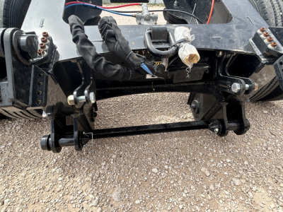 Load King FL201-37-54.5 trailer flip axle underside with hydraulic lines and hardware showing frame and mount bolts.