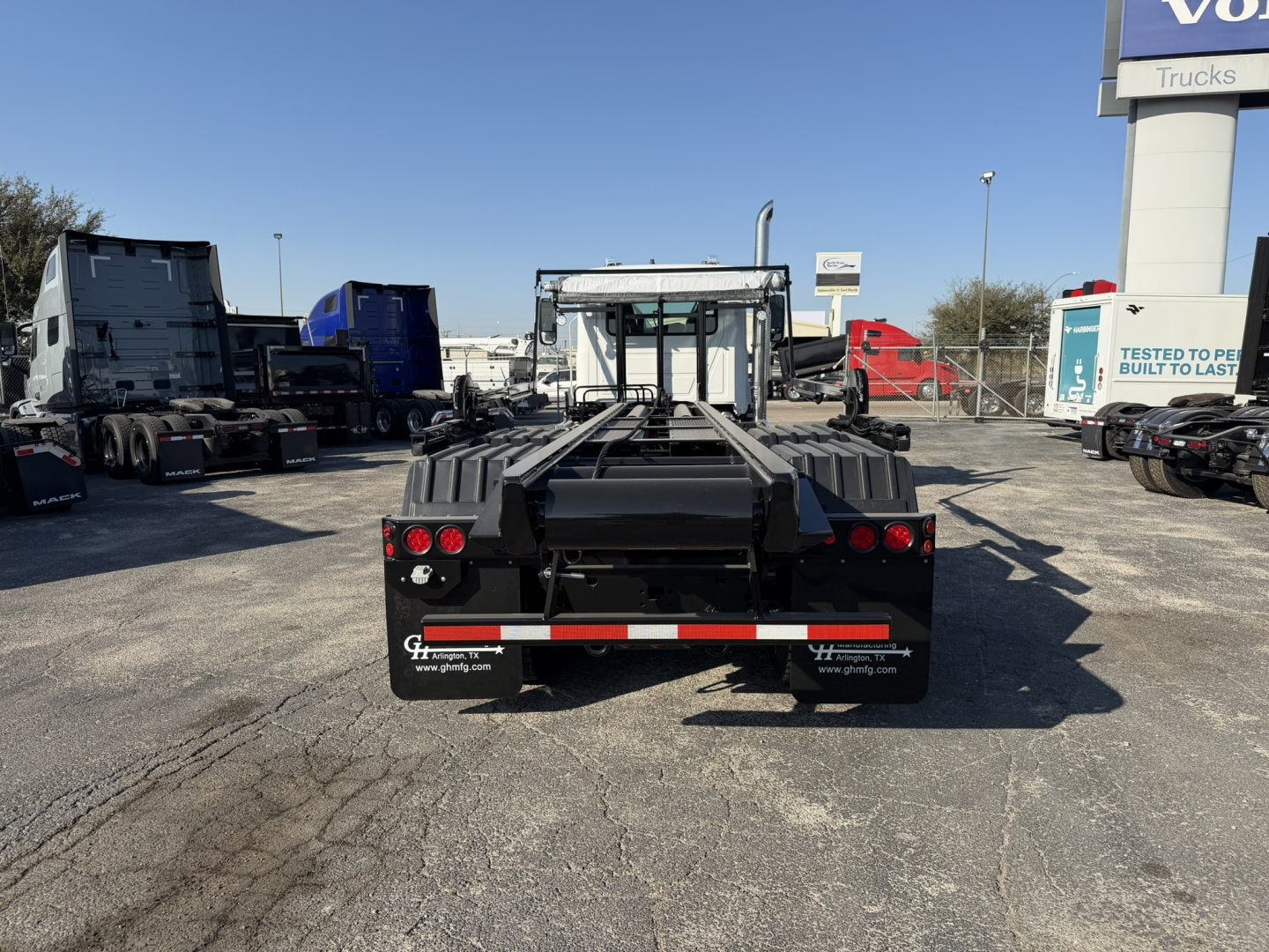 Rear view of a new 2026 Mack GR64B roll-off truck showing the chassis and rear ballast, with no visible text legible.