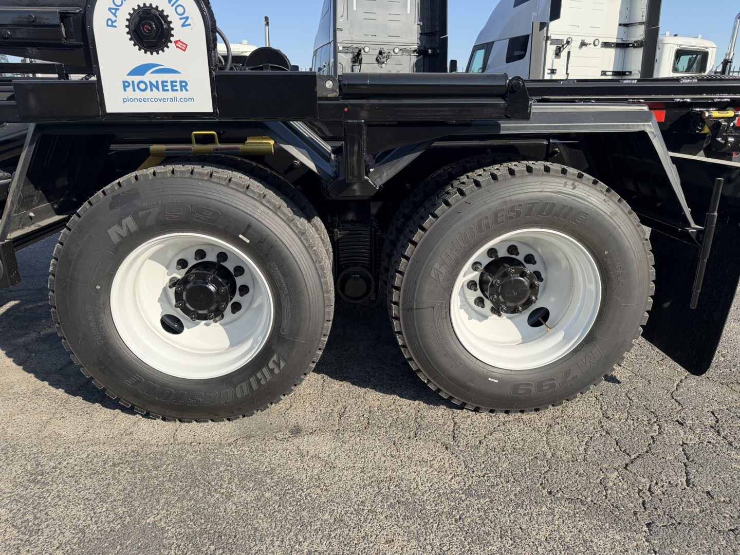 Mack GR64B chassis showing dual rear axles with large off-road tires and white steel wheels.
