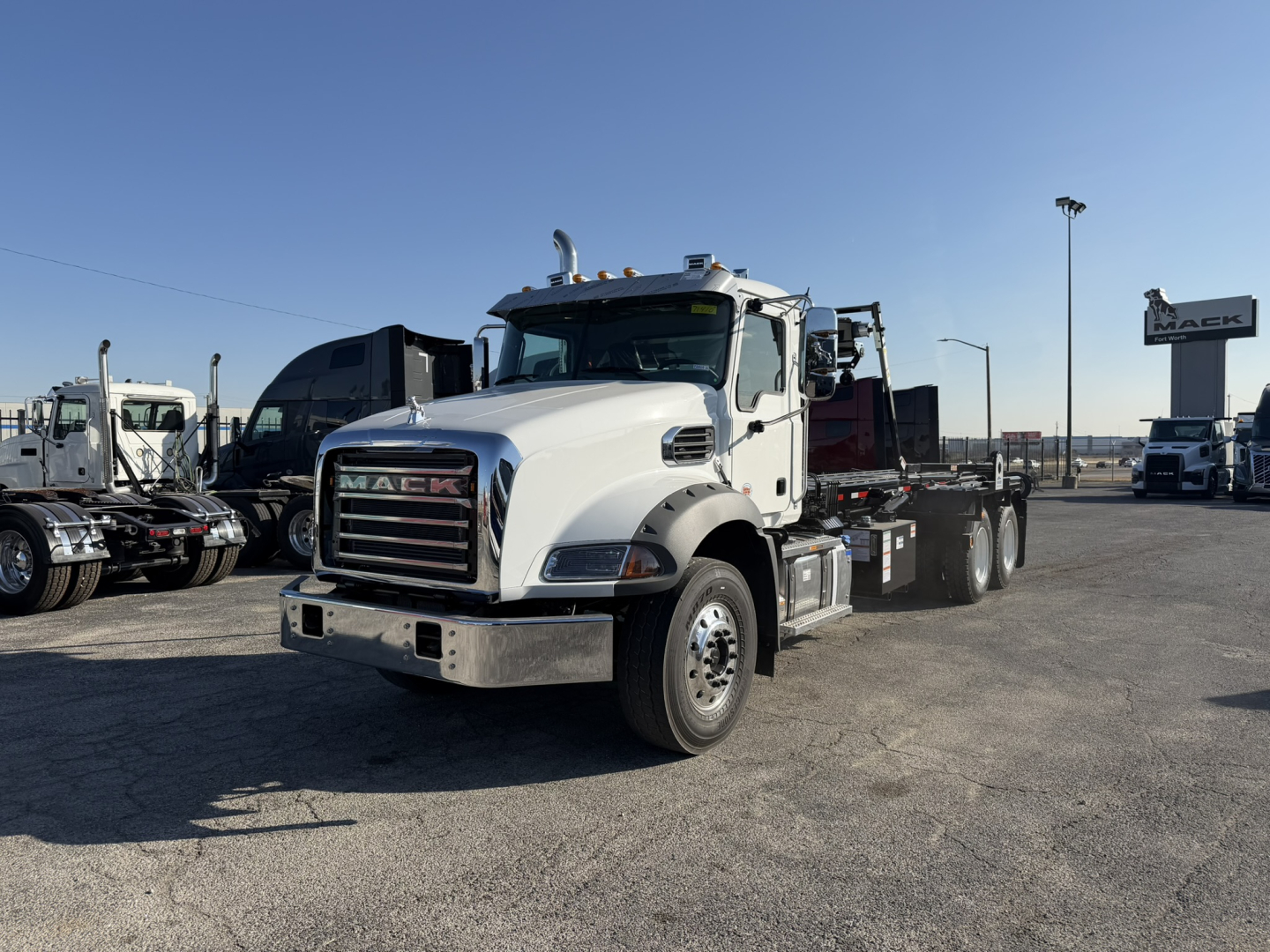 2026 Mack GR64B truck in a lot, front-three-quarter view showing cab and chassis with chrome bumper and Mack grille.
