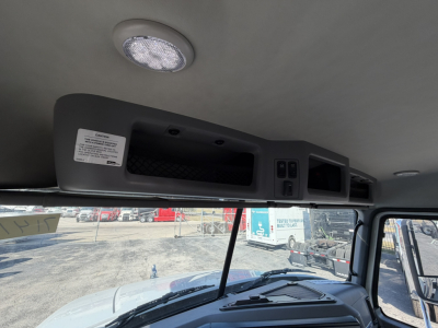 Cab interior overhead console of a 2026 Mack GR64B roll-off truck showing a storage compartment and control panels.