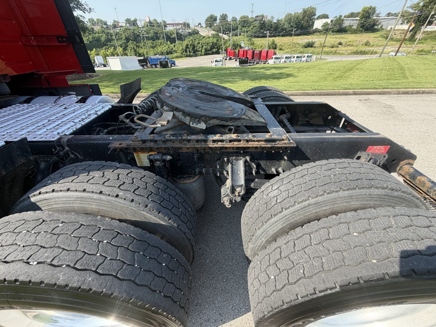 Rear chassis and dual rear axles of a Volvo VNL truck showing fifth wheel and fuel/air lines with tires and frame components.