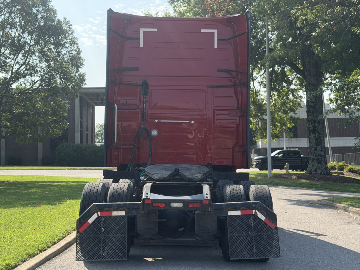 Rear view of a 2022 Volvo VNL64T760 truck with rear sleeper cab, showing dual rear axles and mud flaps.