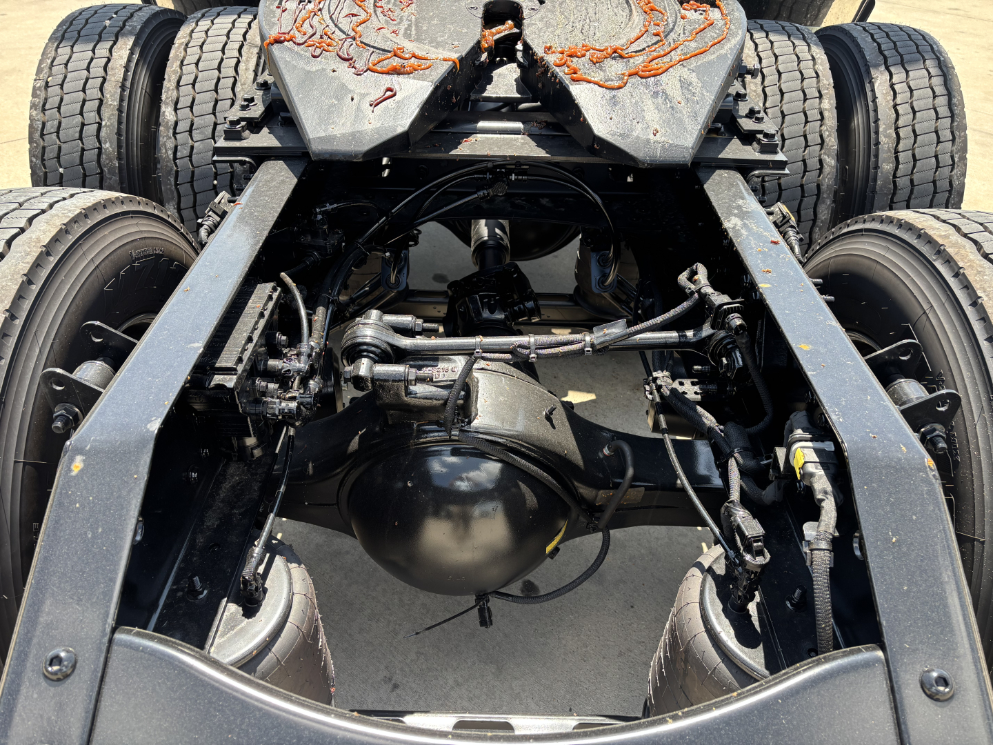 Volvo VNL chassis rear undercarriage showing dual rear axles and differential housing with suspension components and drive shafts.