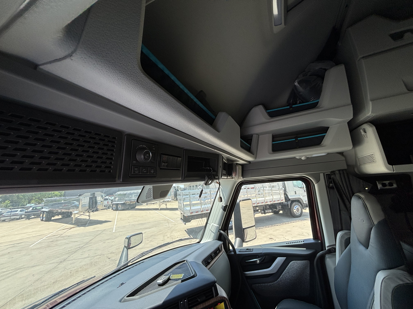 Volvo VNL64T860 cab interior showing dashboard controls and overhead storage.